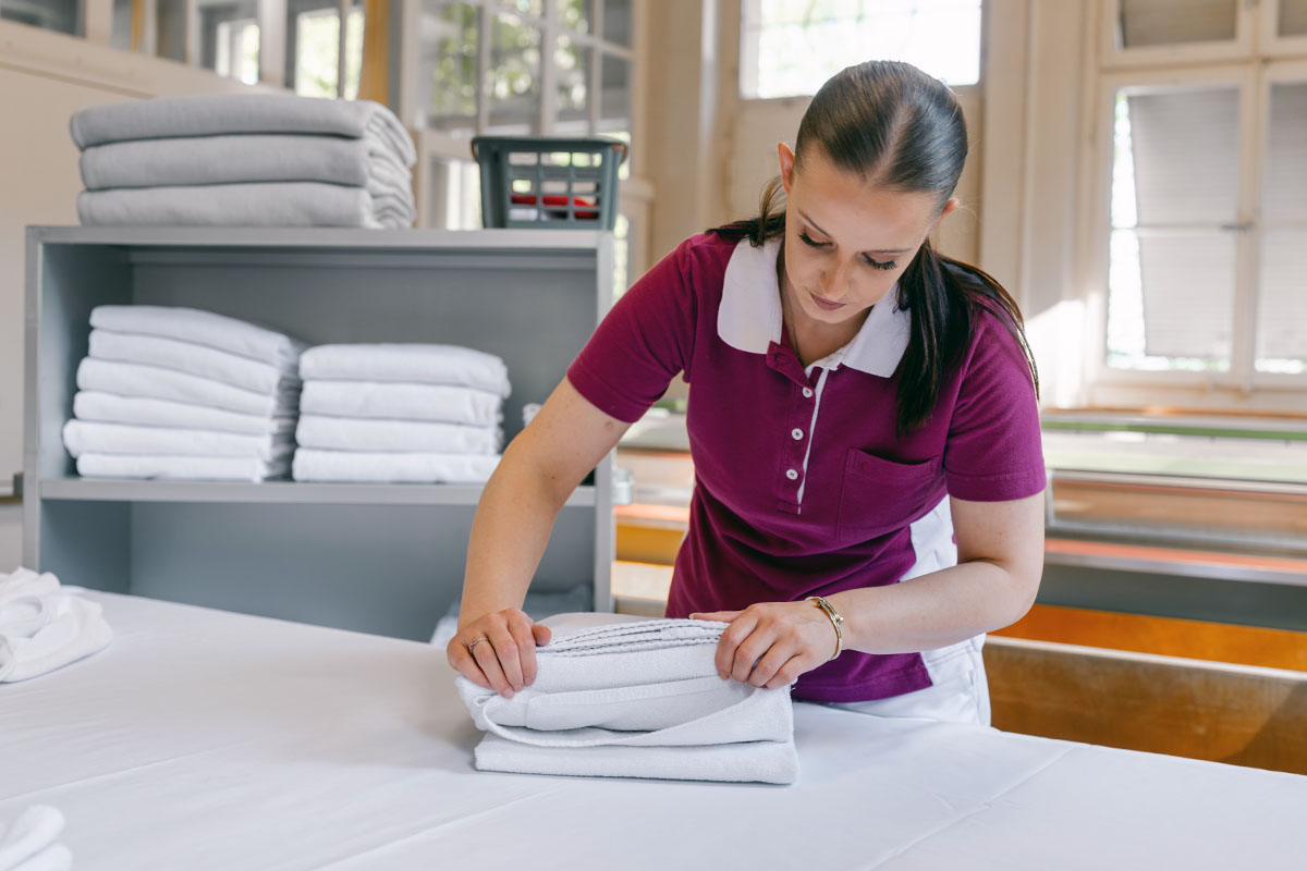 Lernende zur Ausbildung Hotelfachfrau legt Handtücher zusammen